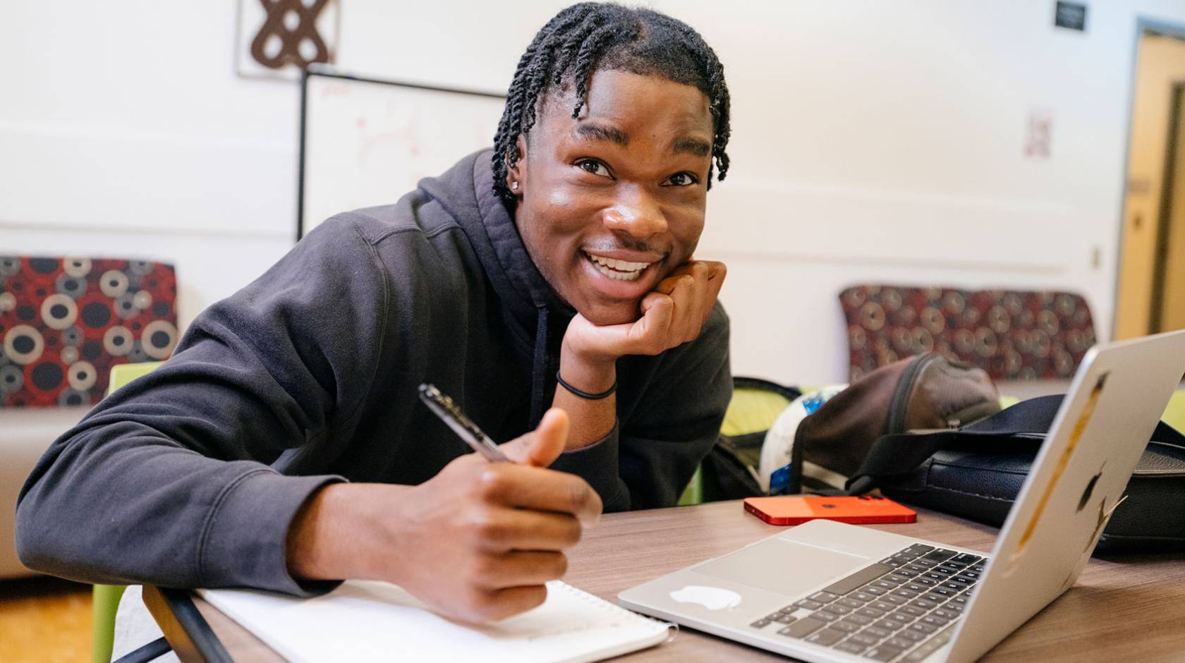 College student looks up from his notes and laptop with a quizzical look on his face