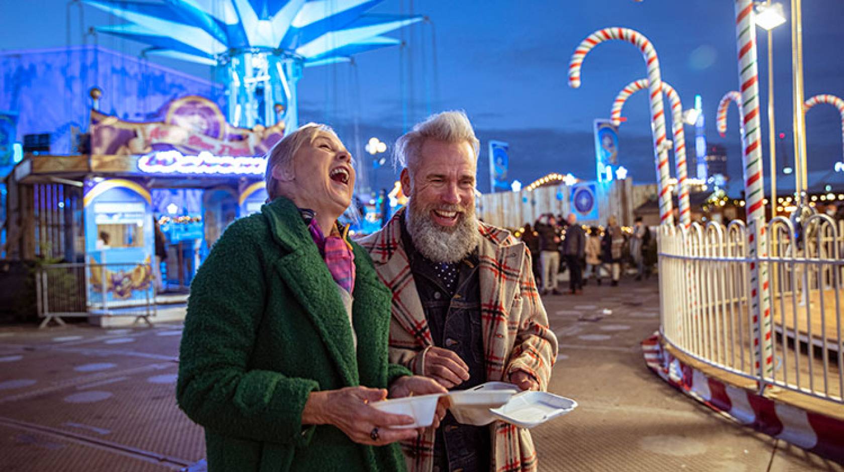 An older couple laughing at a carnival