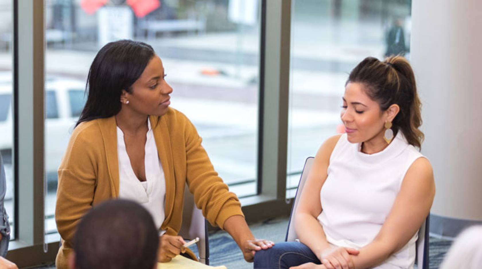 Woman comforts another woman while sitting in a circle