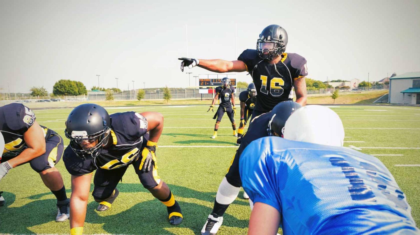 A quarterback points over an offensive line during a football game