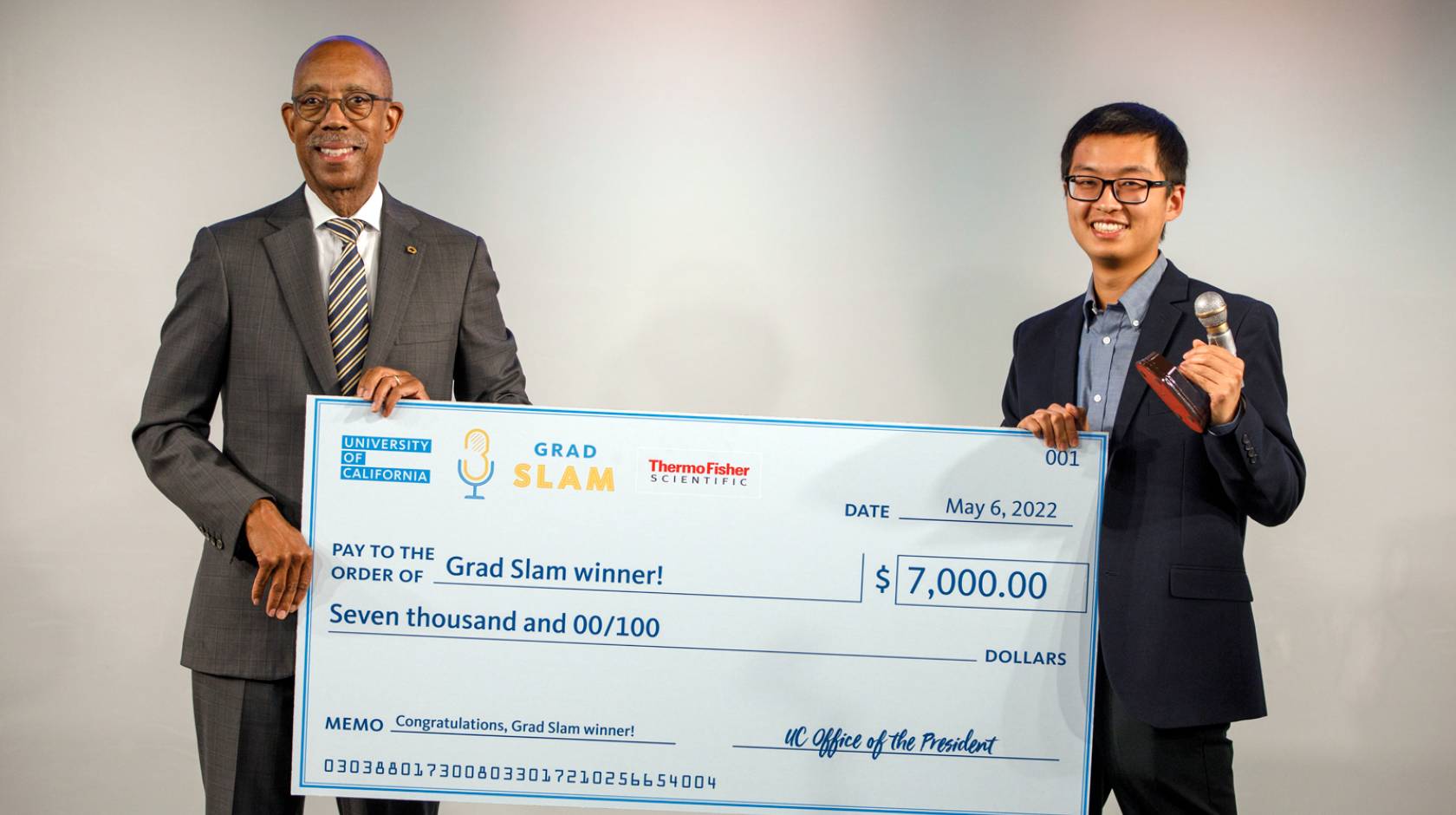Justin Lee holds up his Grad Slam victory check with President Drake