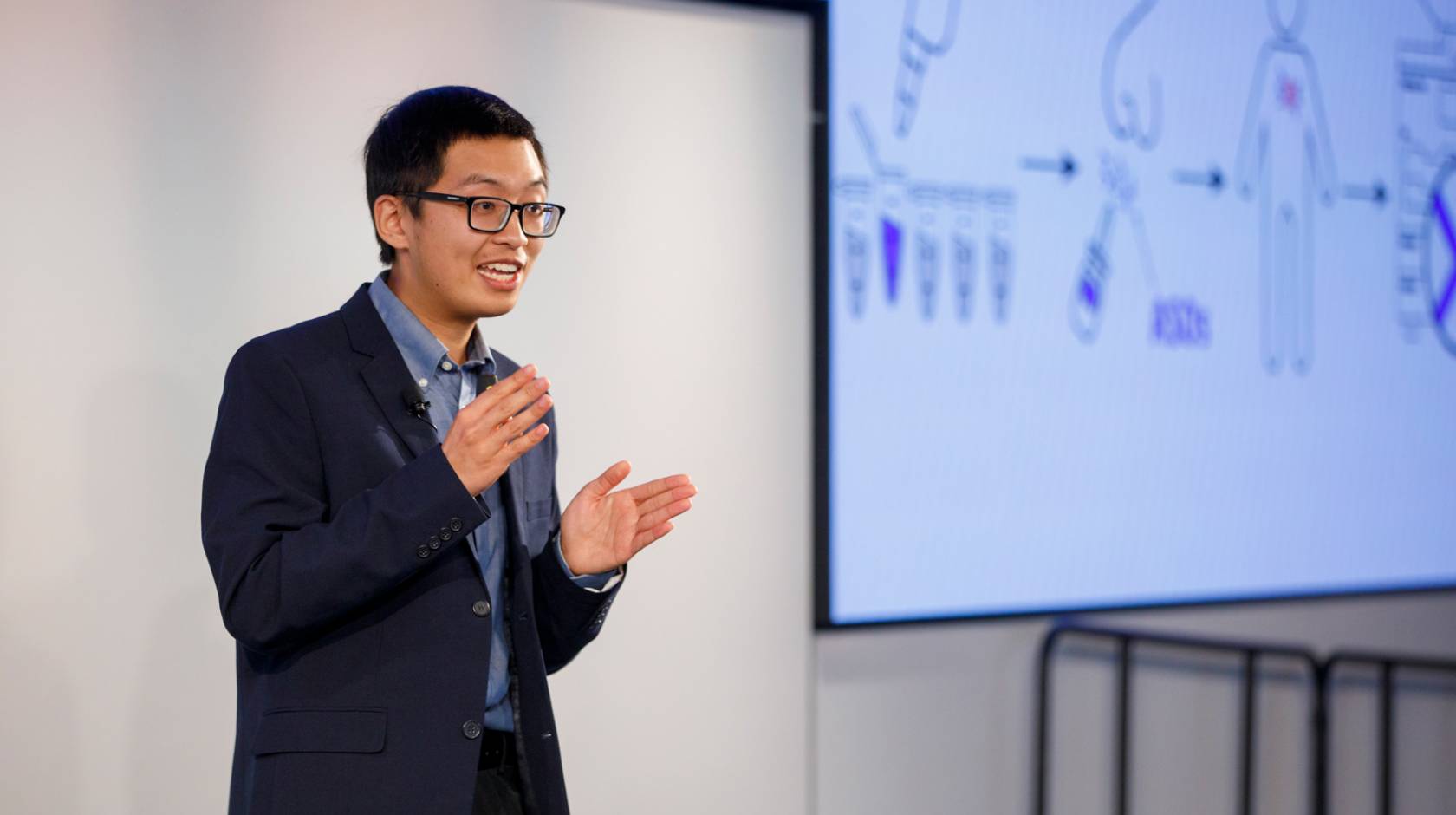 Justin Lee delivers his Grad Slam talk with a projected screen behind him