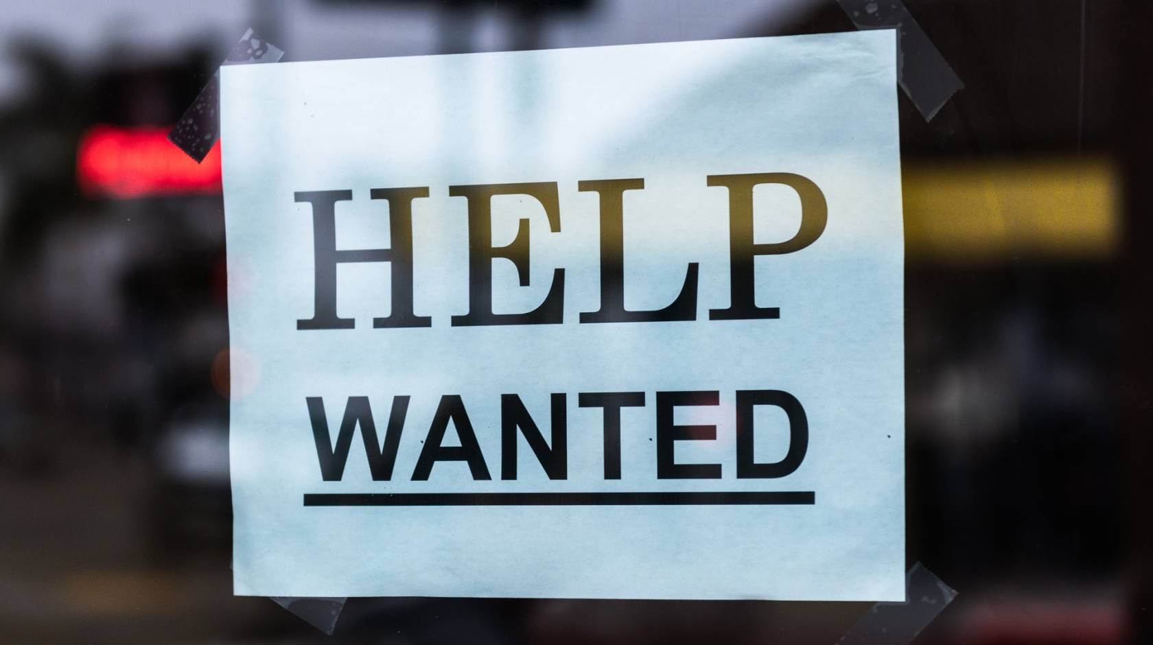 Help Wanted sign in a shop window