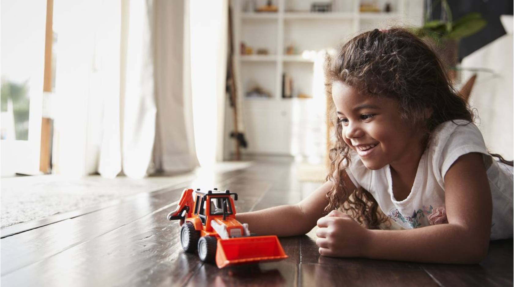 A girl playing with a truck