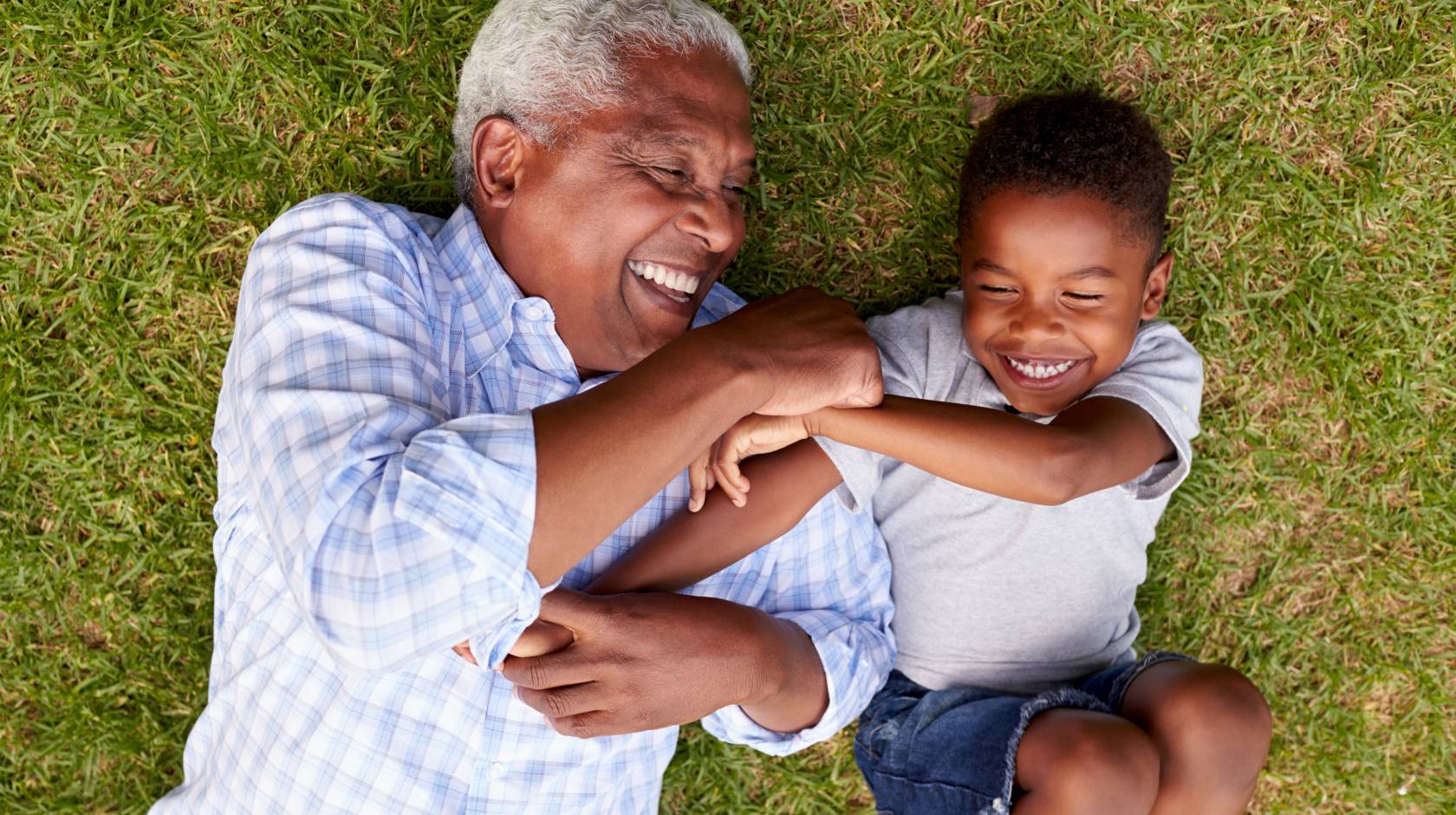 Aerial view of grandfather and grandson playing together on grass