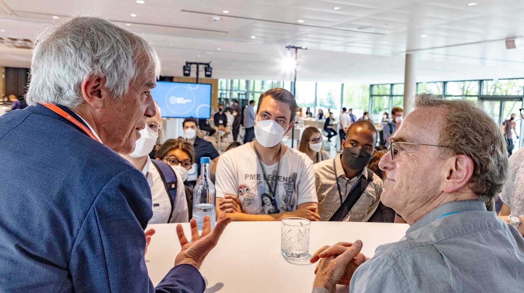 Randy W. Schekman (on the right) and Martin Vetterli speak in front of masked students