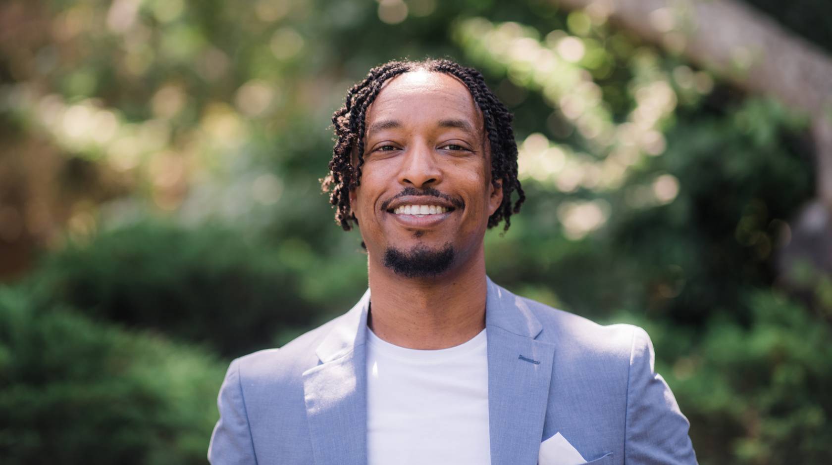 Smiling young Black man in a powder blue blazer, Merhawi Tesfai