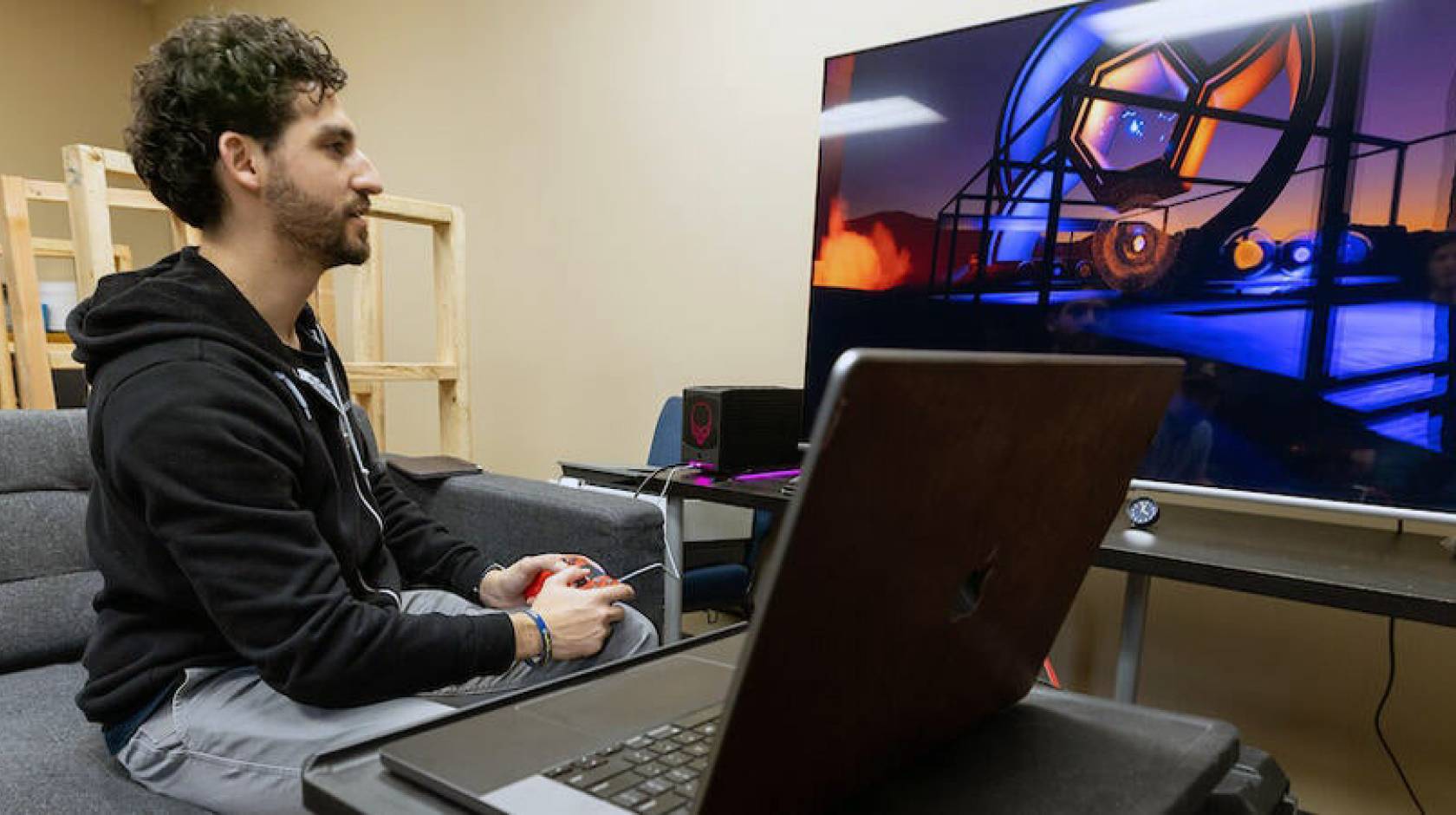 A young man with a beard playing a video game