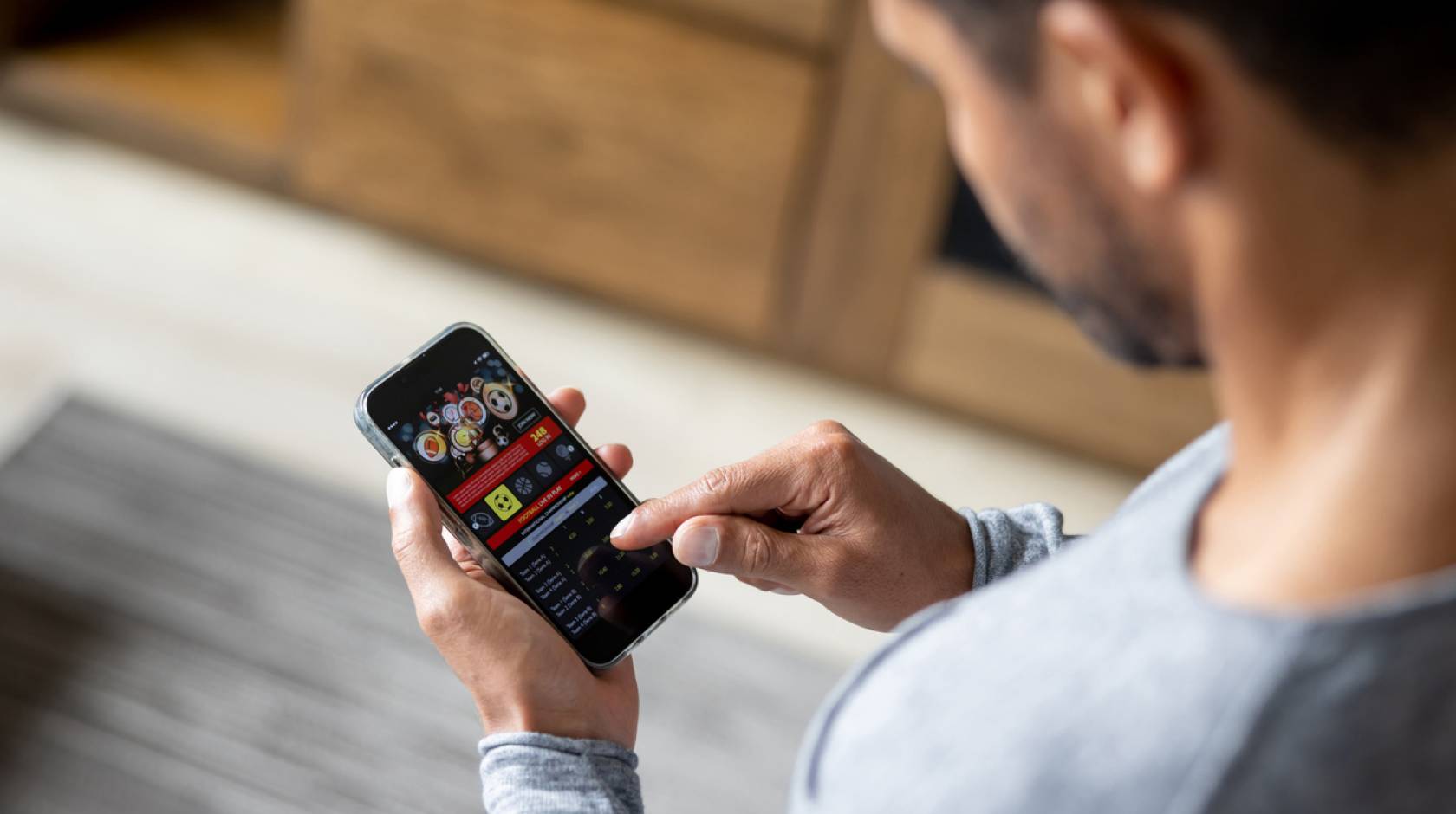 Man looks at gambling app on smartphone