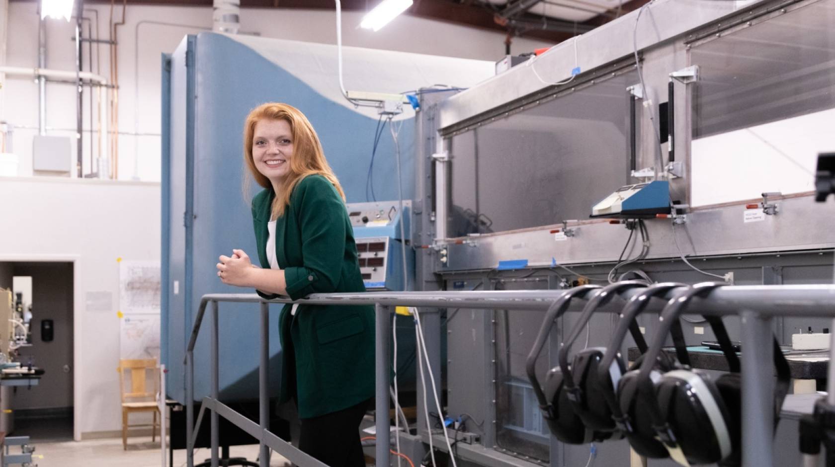 Young woman with red hair and a green cardigan in a laboratory