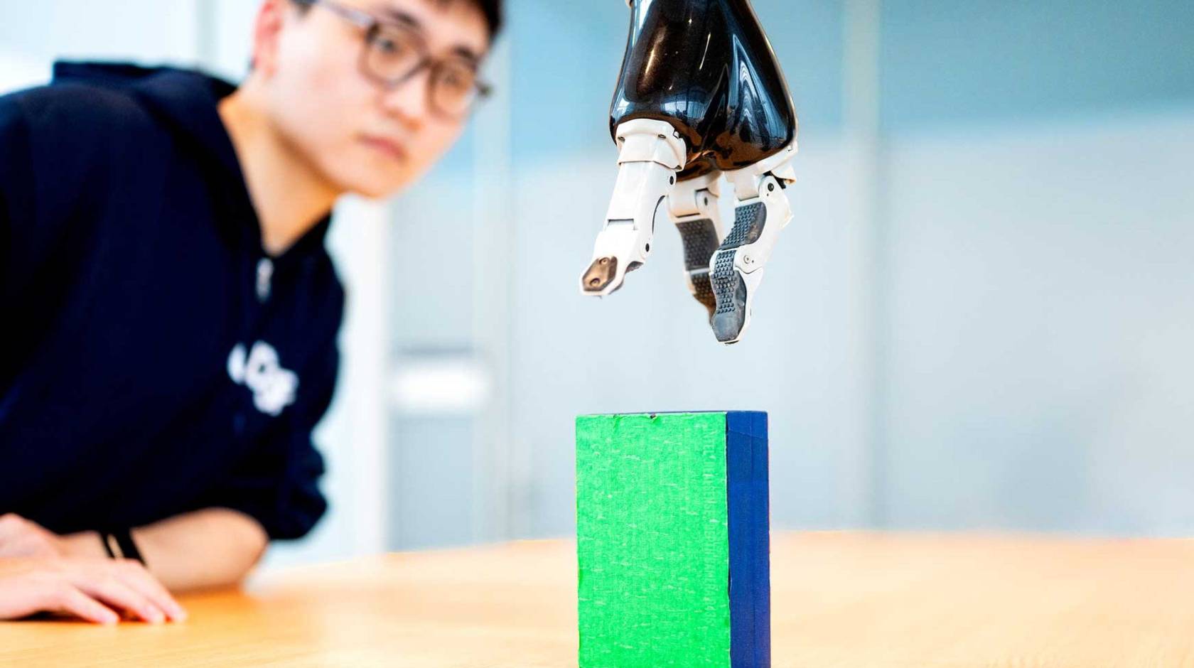 a researcher working with a robotic arm