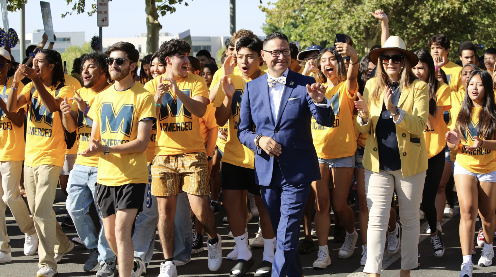 Chancellor Muñoz leads a group of students in yellow T-shirts