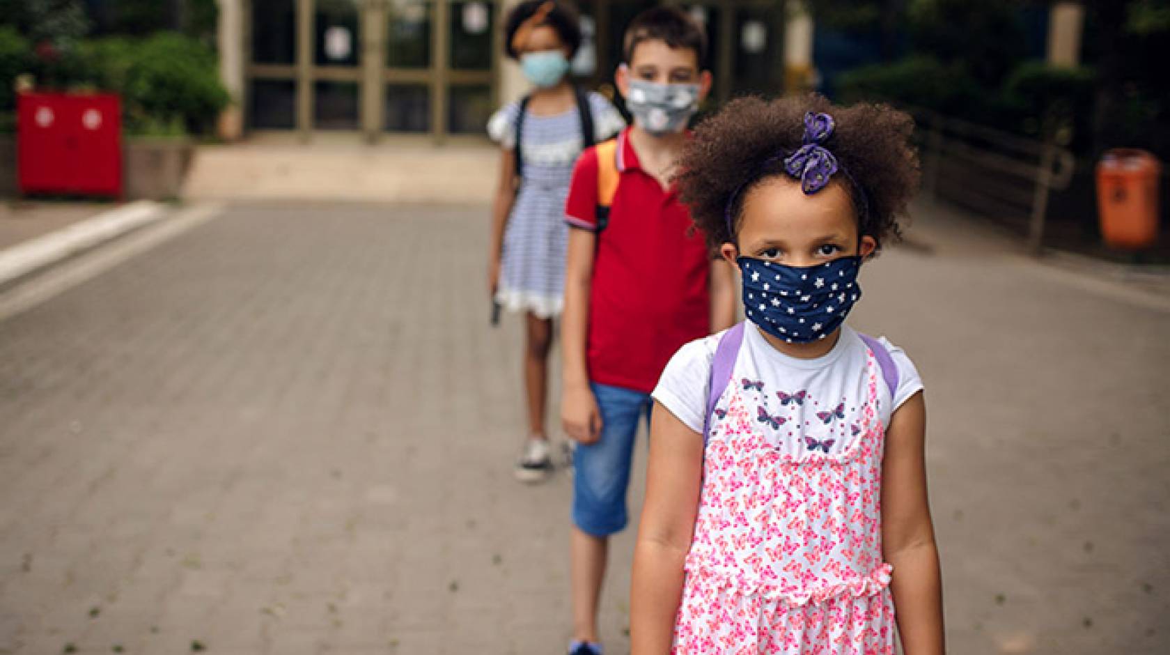 A line of young masked elementary school students