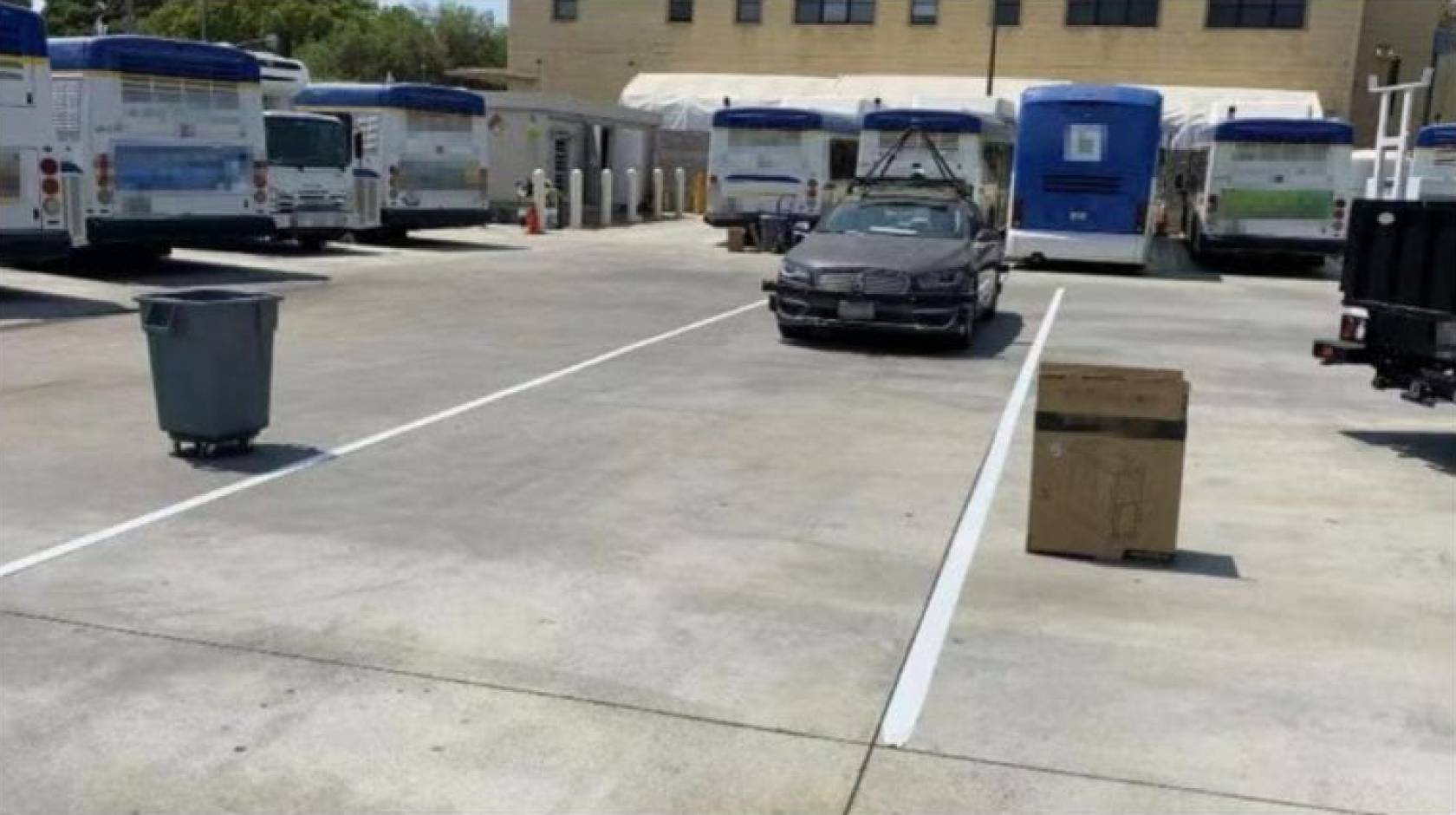 An autonomous car being tested by several common objects, including a trash bin