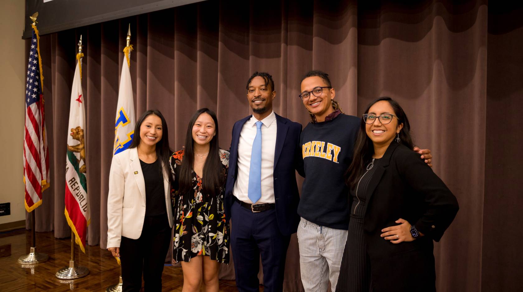 From left to right, current Student Regent Marlenee Blas Pedral, Mary Tran, Student Regent-designate Merhawi Tesfai, William Carter and Deniss Martinez posing for photo in a conference room