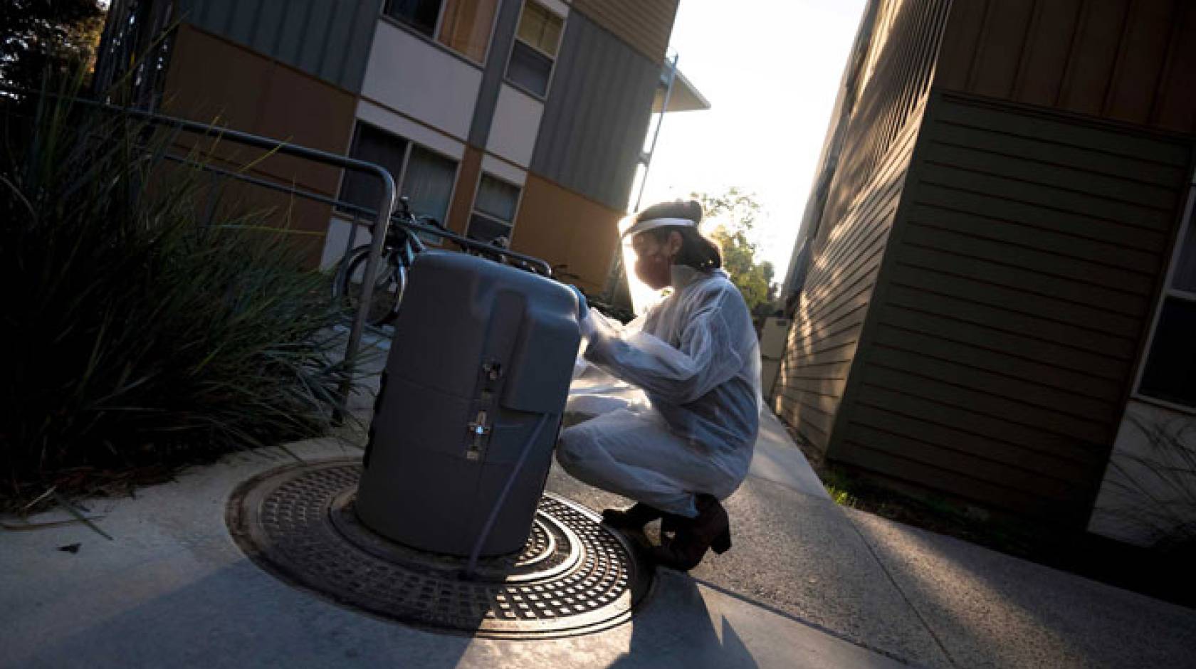 A woman in PPE tests wastewater on campus