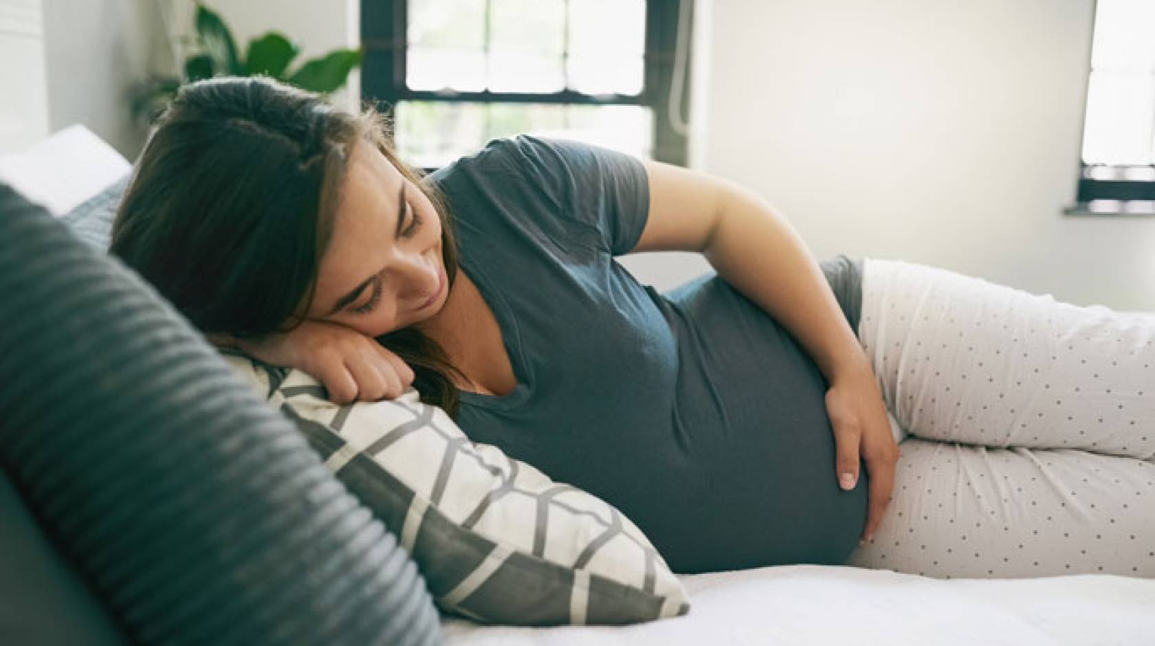 A pregnant woman relaxed on a bed