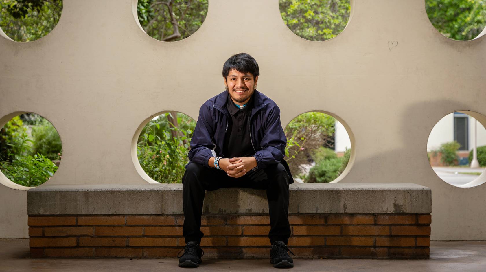 A smiling man sitting on a bench