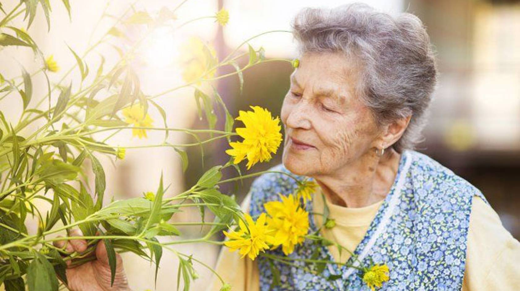 Older woman smelling flowers