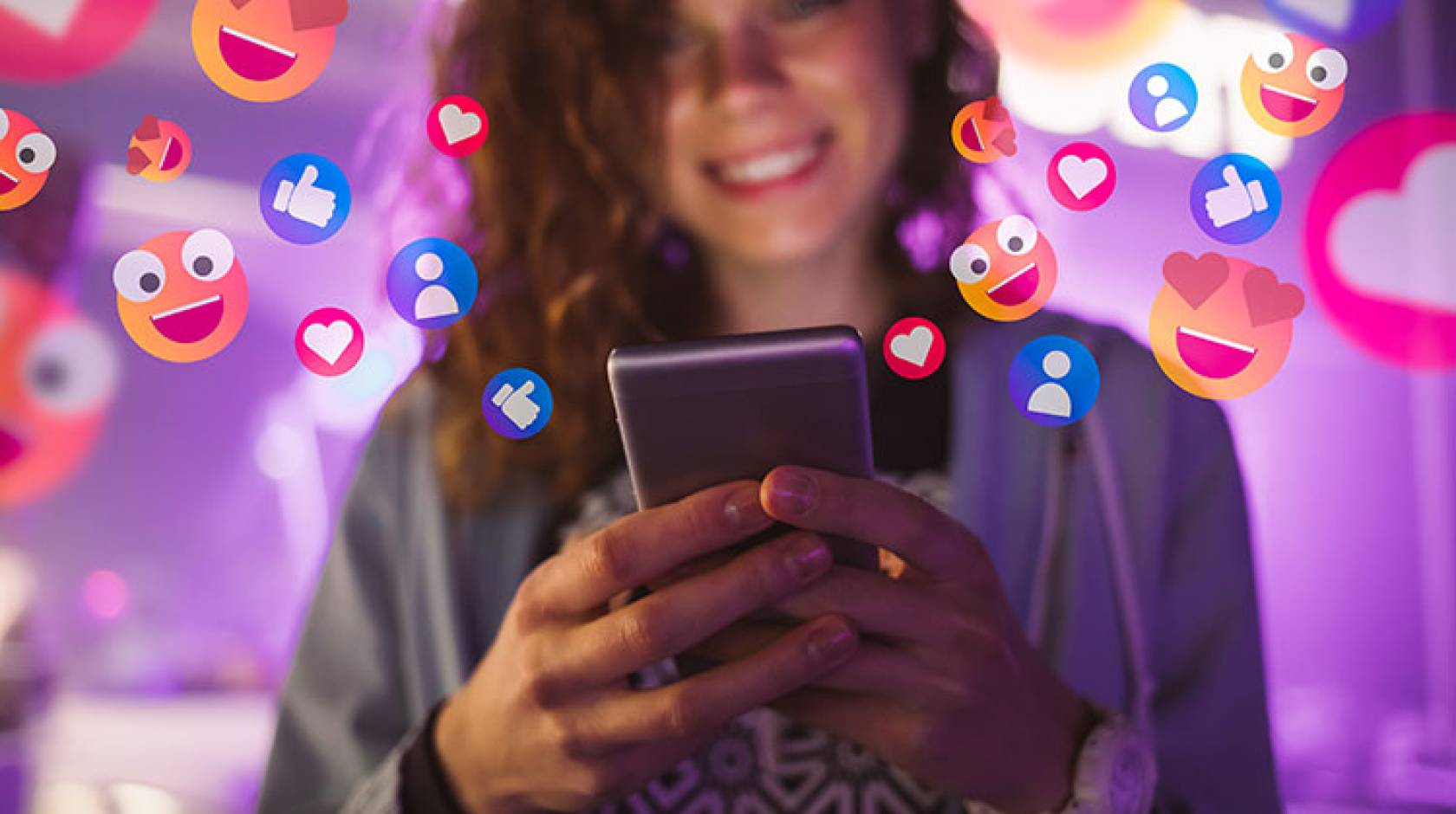 Happy young woman using her phone with emojis surrounding her