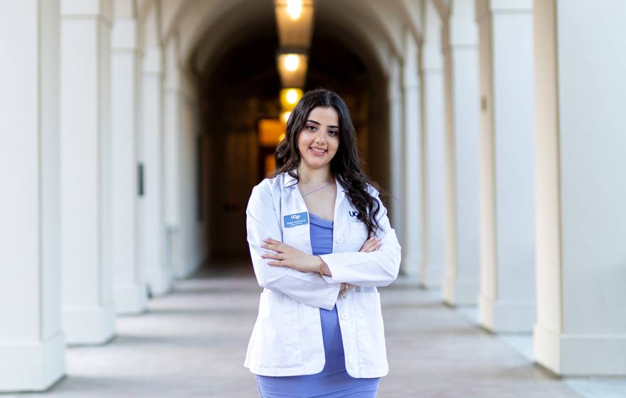 A smiling woman in a white doctor's coat