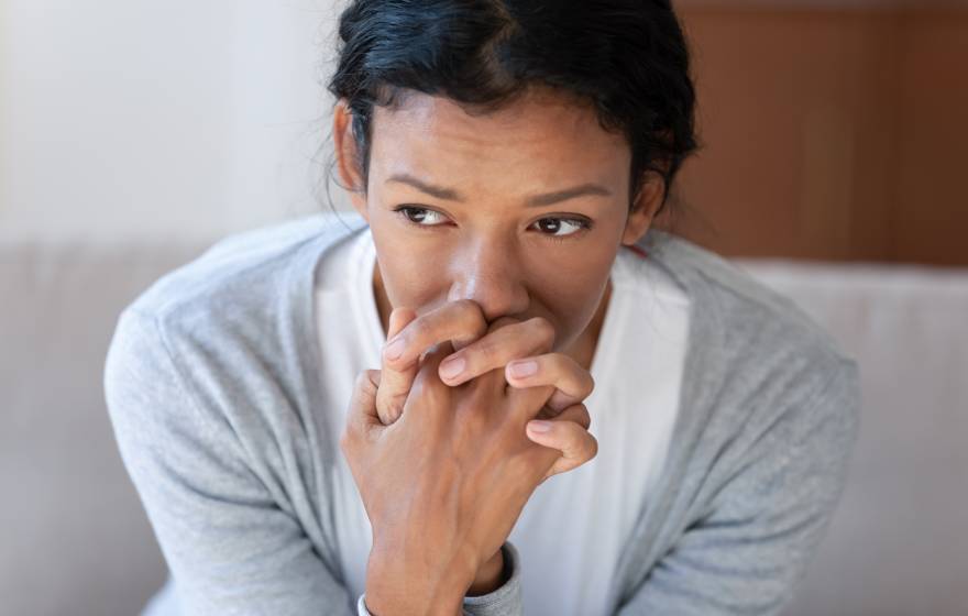 Pensive African American young woman looking in distance thinking pondering