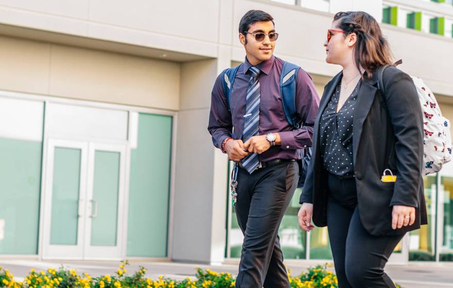 Join the free HireUC career fair August 21 at the Fresno Convention Center Two young people walk outside talking together in business casual clothing