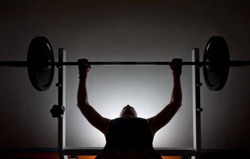 Man lifting weights in silhouette