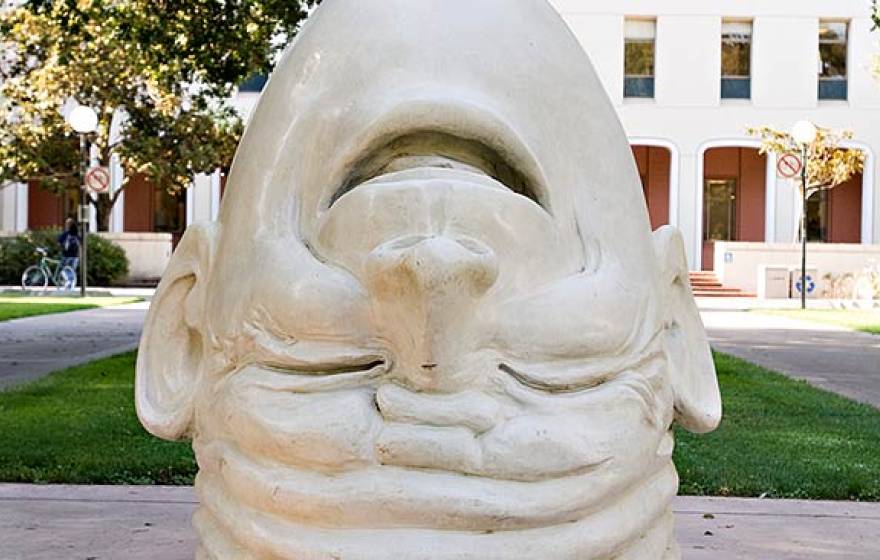 A UC Davis Egghead sculpture - an upside down head sculpture, laughing