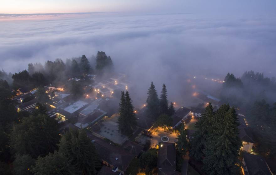 Pacific coastal fog A view from above of heavy fog rolling from a reddish sky over a twilit UC Santa Cruz campus