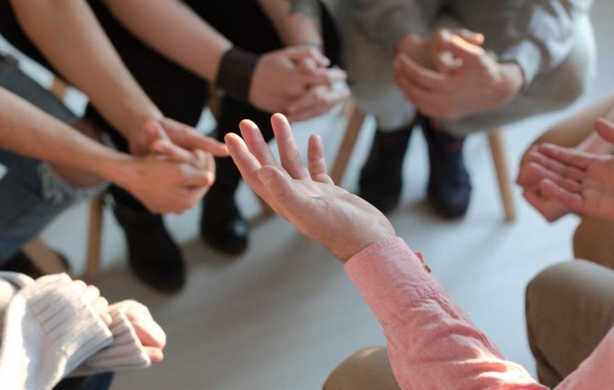 photo of hands from a group of people in discussion