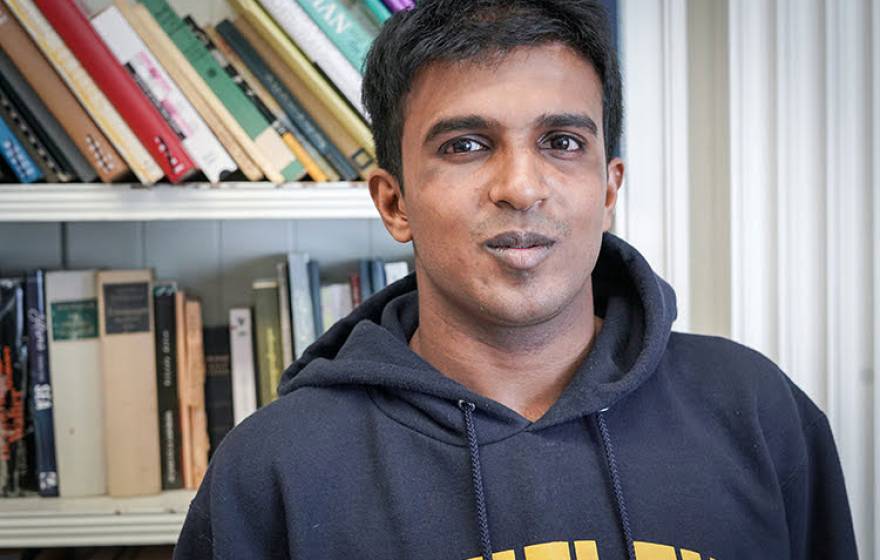 Hari Srinivasan in front of a bookcase