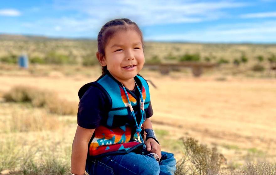 HT, a Navajo toddler, smiling at home