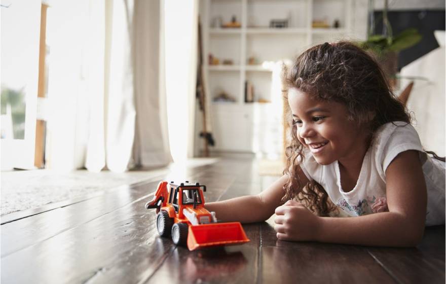 A girl playing with a truck