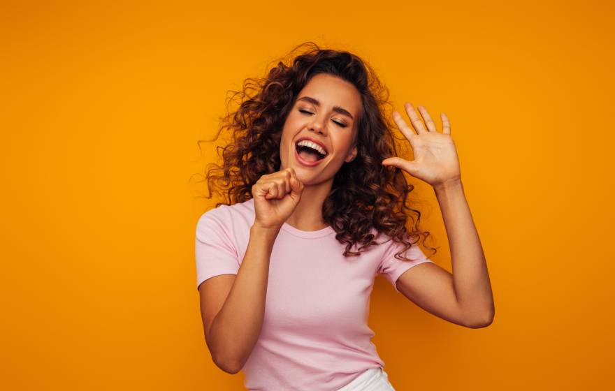 A woman singing into an air microphone