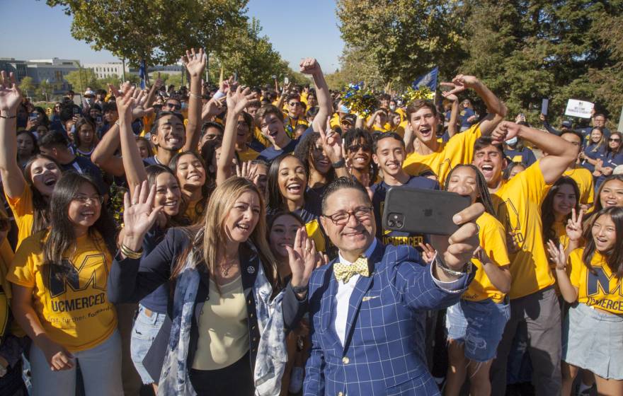Chancellor Juan Sánchez Muñoz takes a super-selfie with his wife, Dr. Zenaida Aguirre-Muñoz, and a multitude of new students at Scholars Bridge Crossing