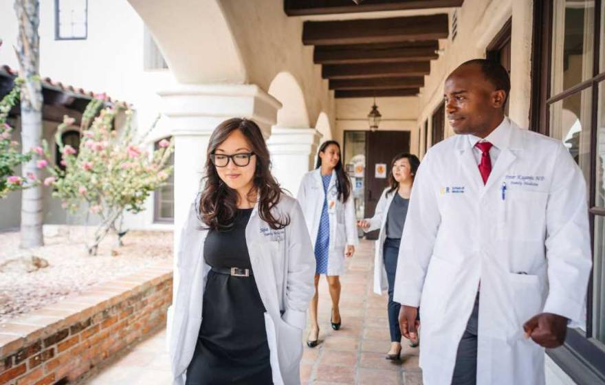 Doctors walking along a breezeway wearing white coats