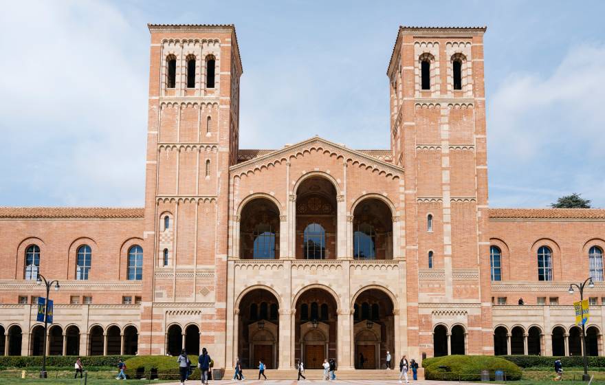 UCLA Royce Hall, a light brick building with two towers, against a slightly cloudy bright blue sky