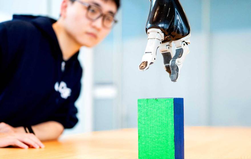 a researcher working with a robotic arm