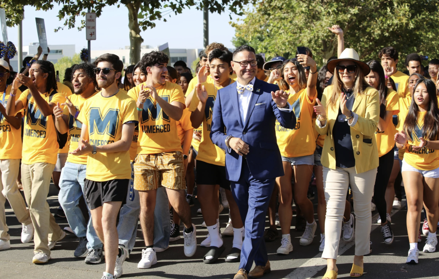 Chancellor Muñoz leads a group of students in yellow T-shirts