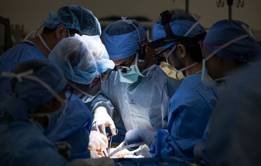 First bladder transplant Six surgeons huddle around someone while operating