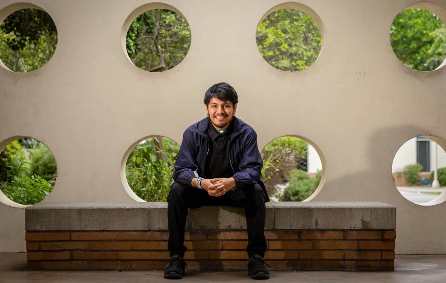 A smiling man sitting on a bench