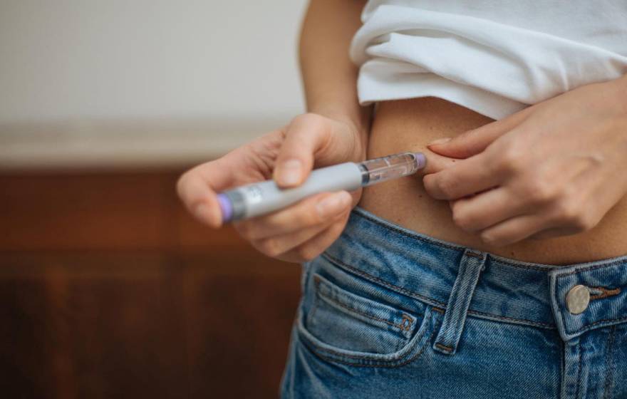 A white woman injecting her midsection