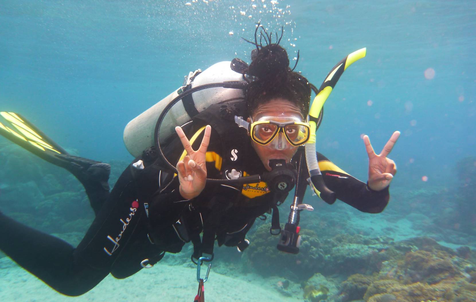UC grad student Camille Gaynus swims underwater with a scuba tank