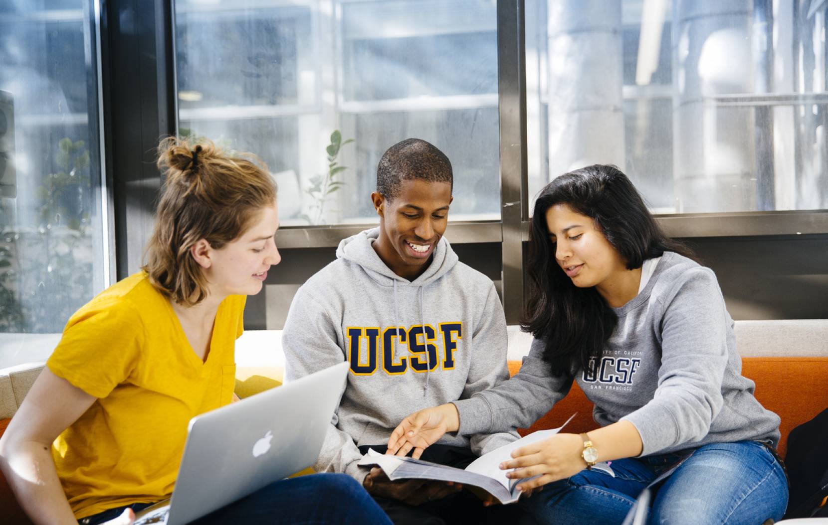 A group of three students, one in a UCSF sweatshirt
