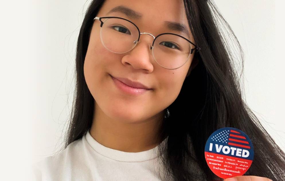 Portrait of a student holding an "I voted" sticker