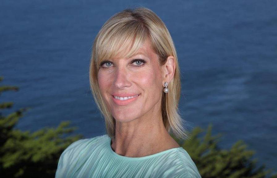 Woman with blonde shoulder-length hair in mint green dress