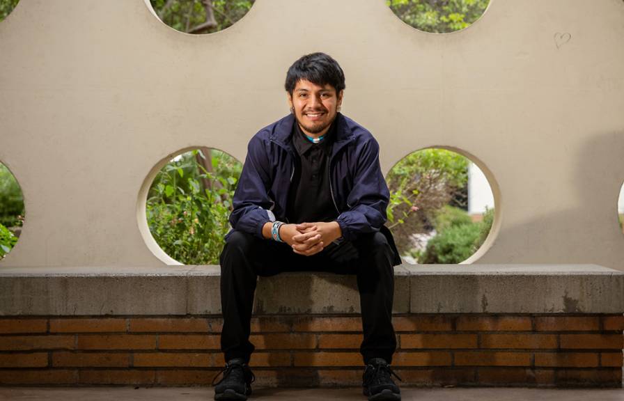 A smiling man sitting on a bench