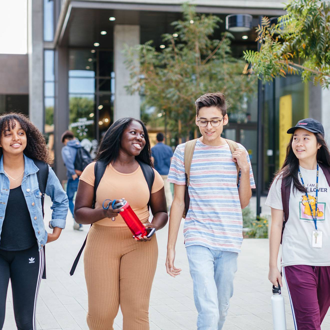 Group of four students walking on campus