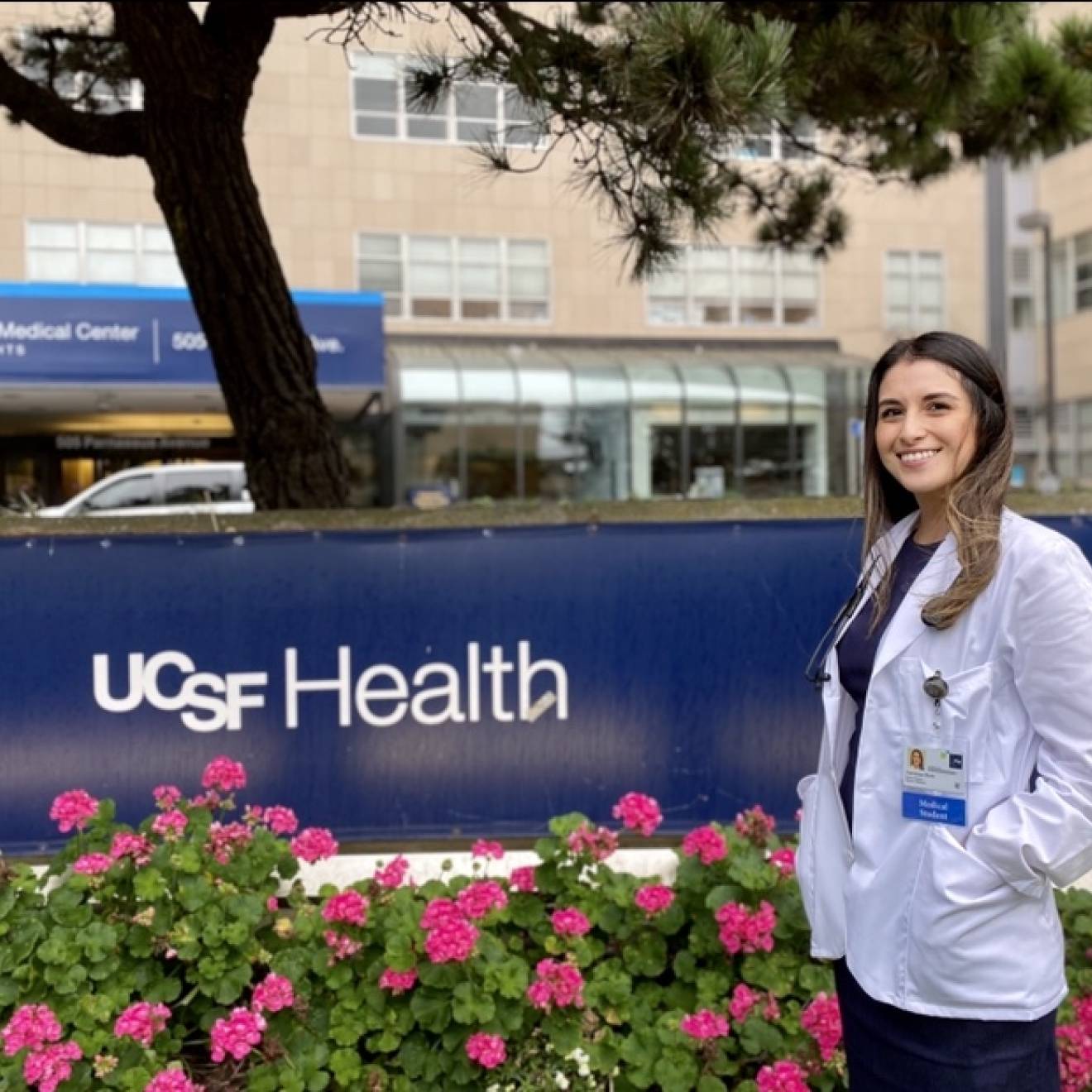Vanessa Mora in her white coat in front of UCSF Fresno